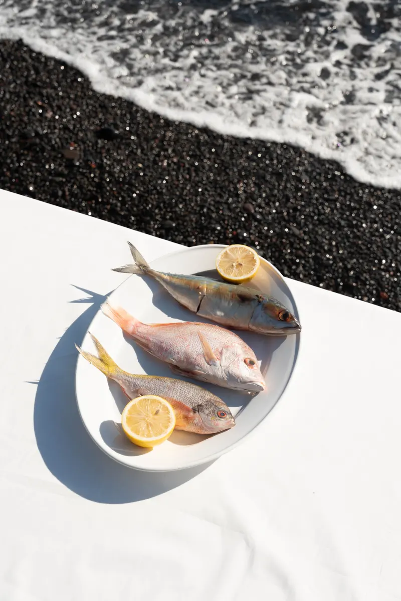 Catch of the day on a white table, with lemon, by the shore.