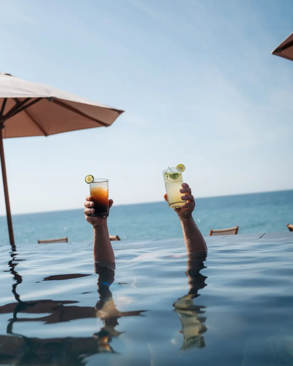 Two glasses raised in the pool.