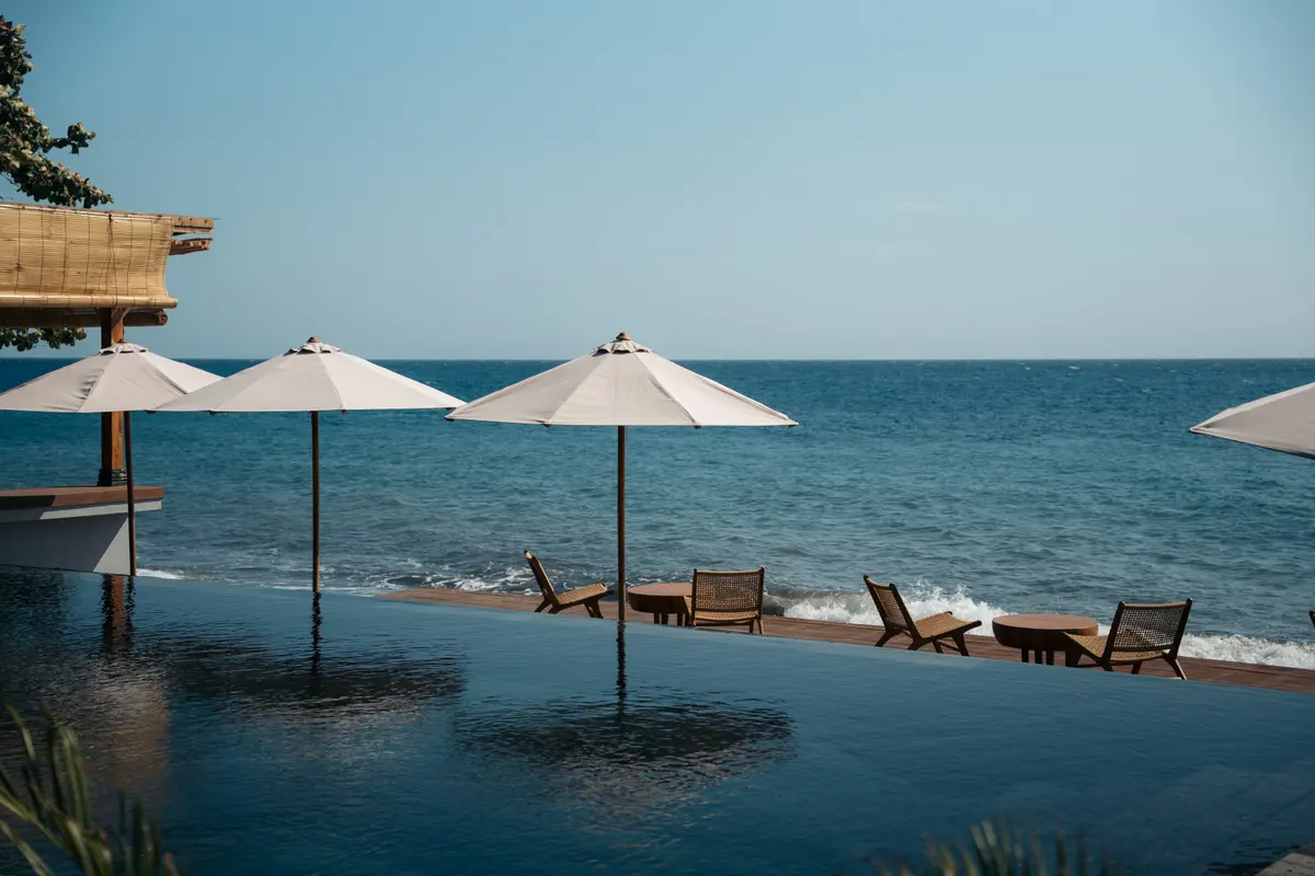 The pool edge, parasols and the sea beyond.
