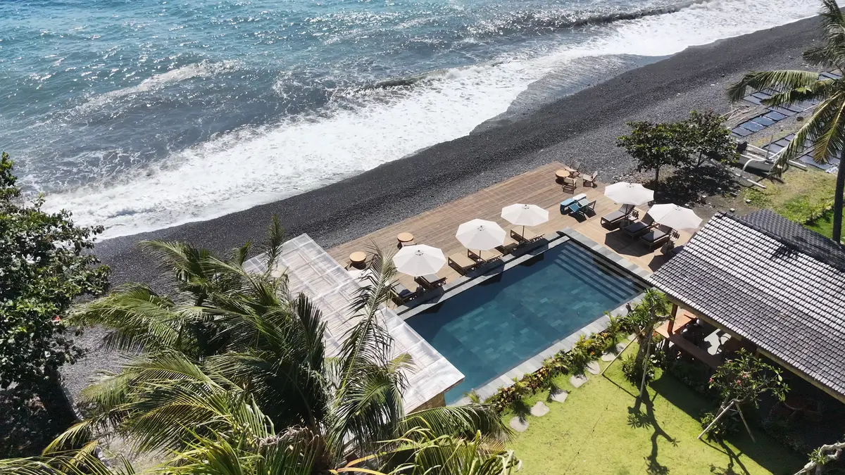 The pool and sundeck from above, beside the pebble shore.
