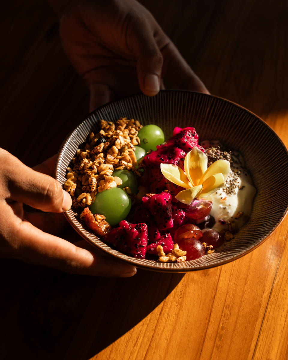 A colourful breakfast bowl on the warm-wood table at Saga